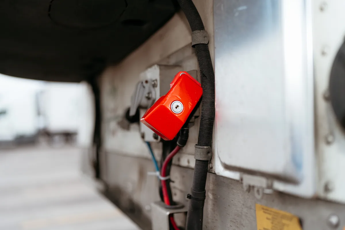 A red ENFORCER lock covering a trailer's air line connection.