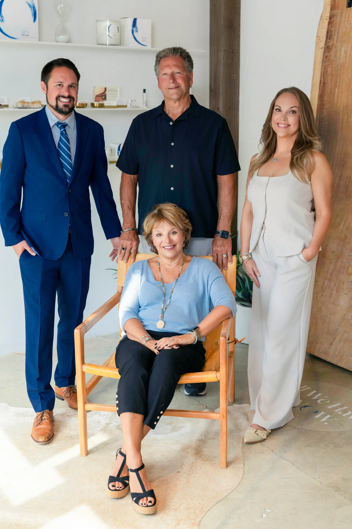 Four members of a massage studio team in their shop, one seated in a leather chair.