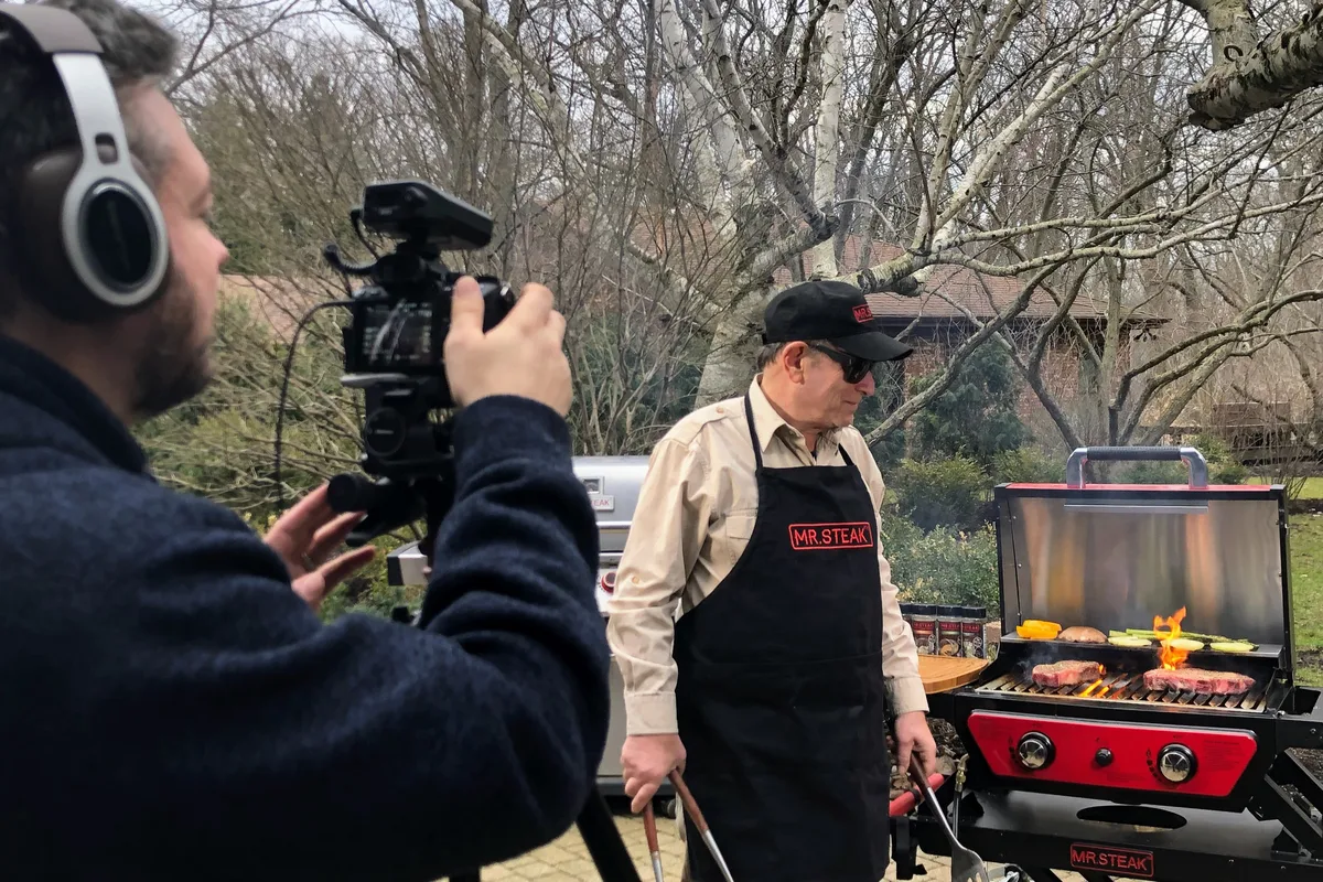 Greg Mulvey filming the founder of Mr. Steak at the grill during the shoot.