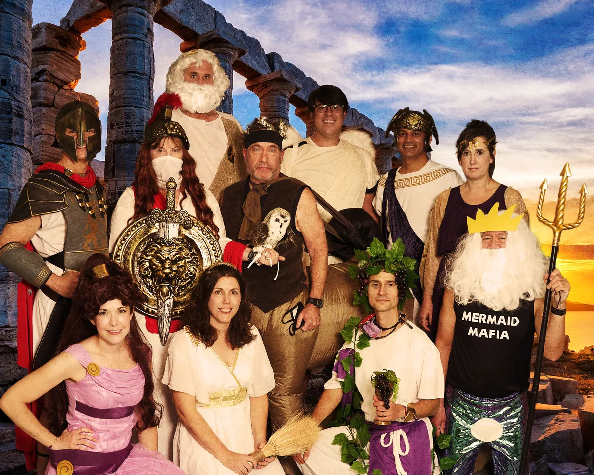 The Laboratory & Pathology Diagnostics physicians in Greek god costumes, composited in front of ancient columns at sunset.