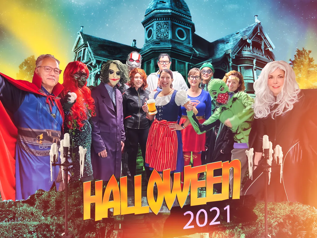 The physicians in superhero and villain costumes, composited in front of a haunted Victorian mansion.