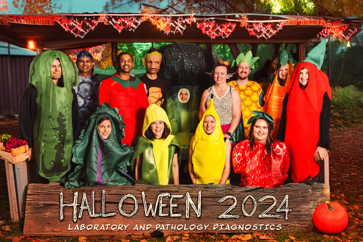 The physicians in fruit and vegetable costumes, composited into a lit-up farm stand.