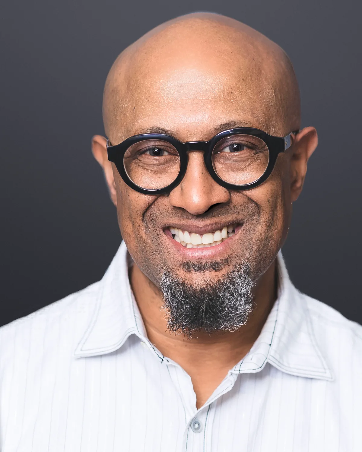 A headshot on a clean grey set brought into the office, even light across the face.