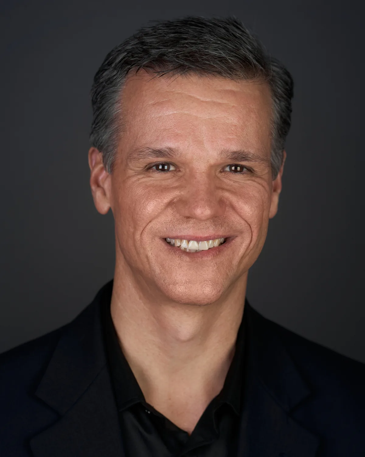 A matching headshot from the same session, same set, same light.