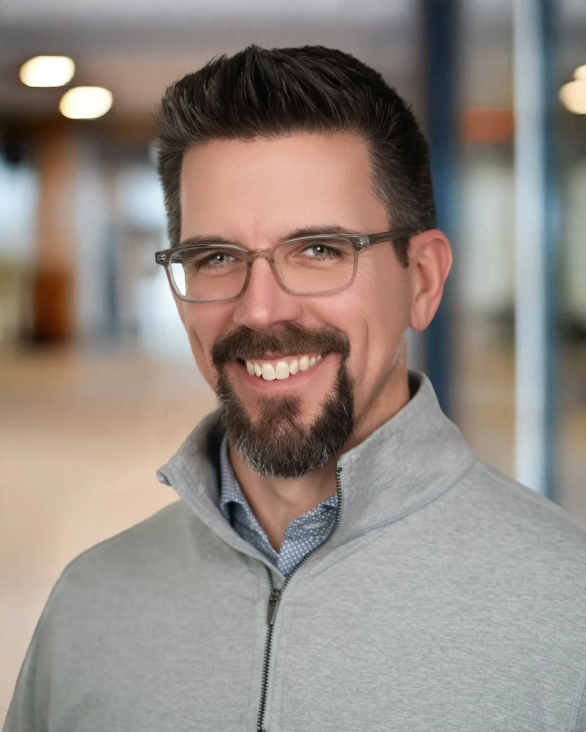A headshot made in a company's own lobby, the room falling away soft behind.
