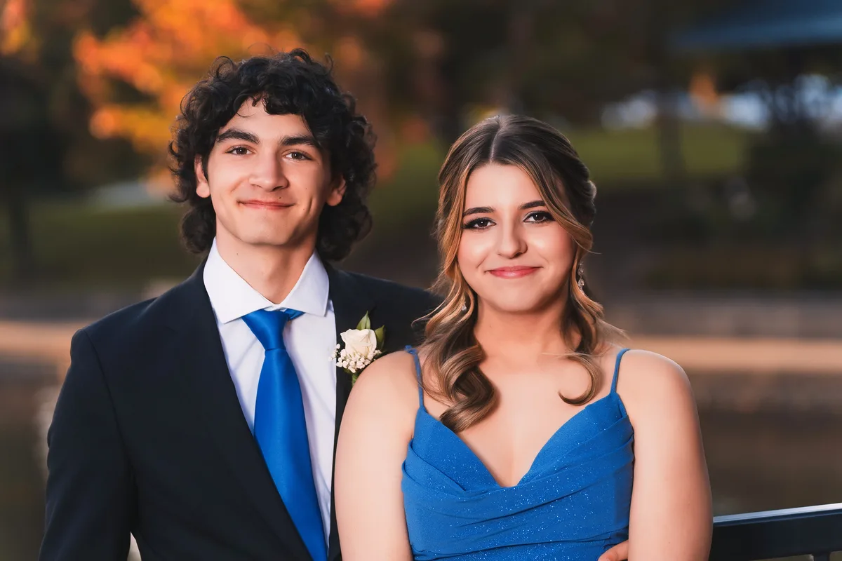 A homecoming couple in evening light, autumn color behind them along the Naperville Riverwalk.