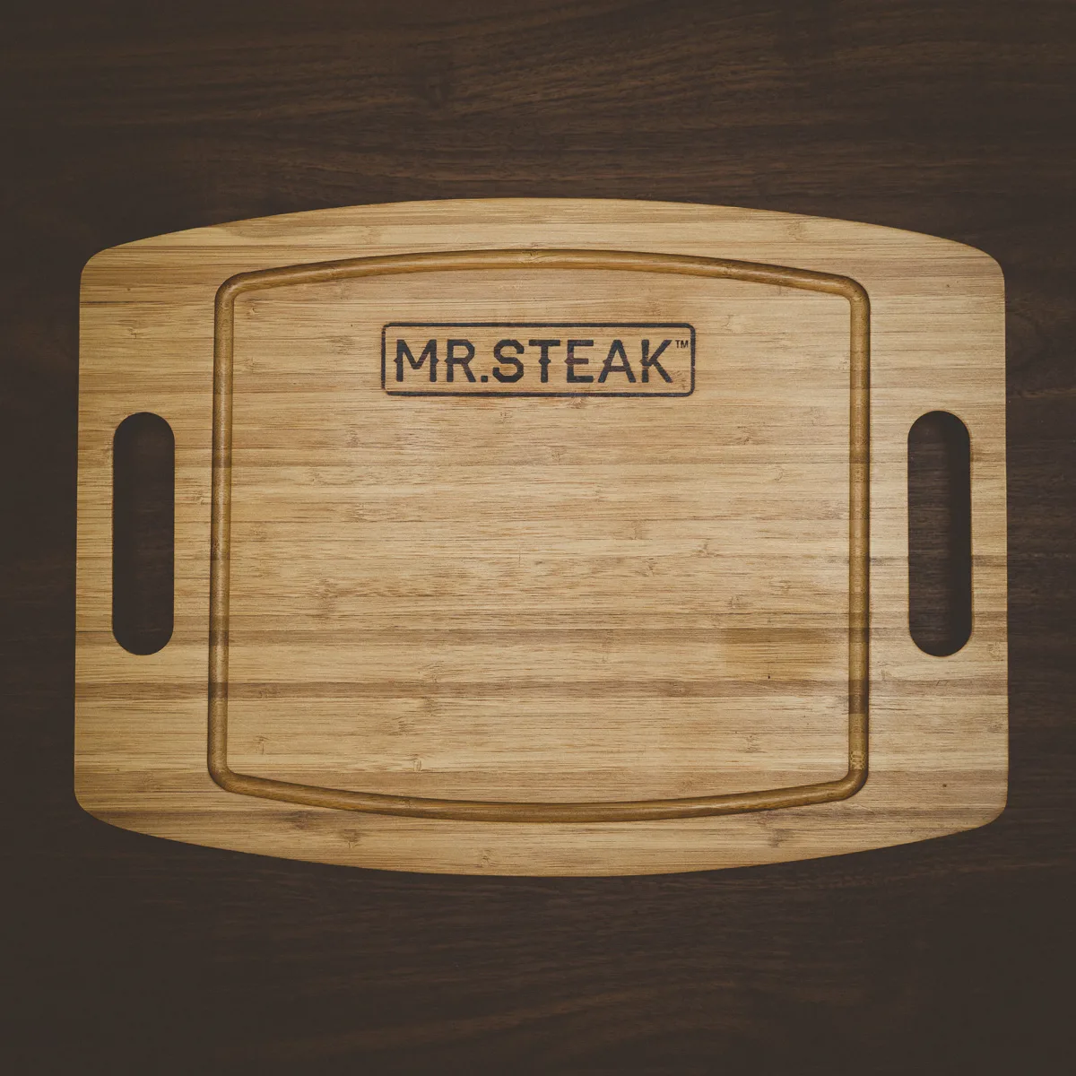 A bamboo carving board branded with the Mr. Steak logo.
